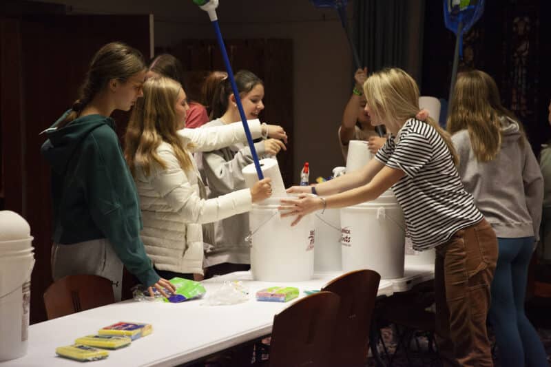 Teenagers putting together buckets of cleaning supplies during a youth outreach event at St. Stephen's Church in Richmond, Virginia